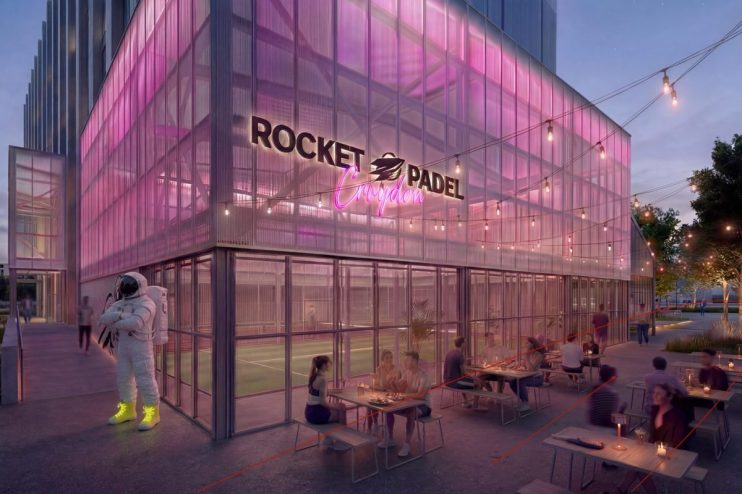 Rocket Padel Croydon exterior at dusk with pink lighting, outdoor dining, and an astronaut statue.
