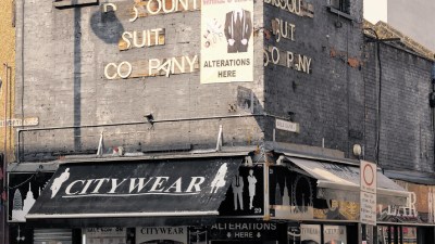 Discount Suit Company building with Alterations Here banner, Citywear awnings, and street signs for Wentworth St. and Bell...