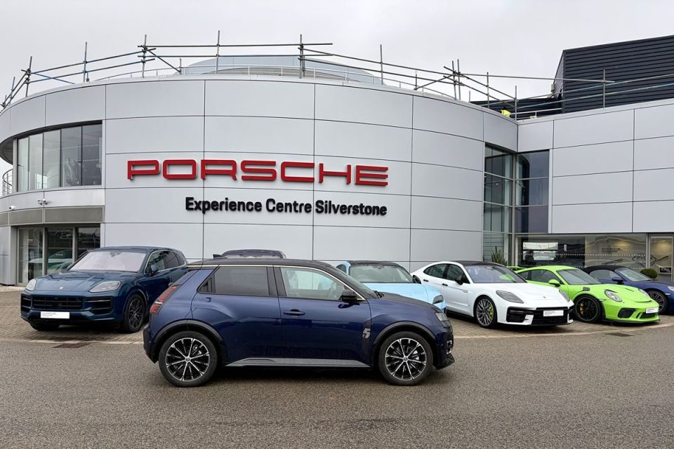 Various Porsche models parked in front of the Porsche Experience Centre Silverstone building.