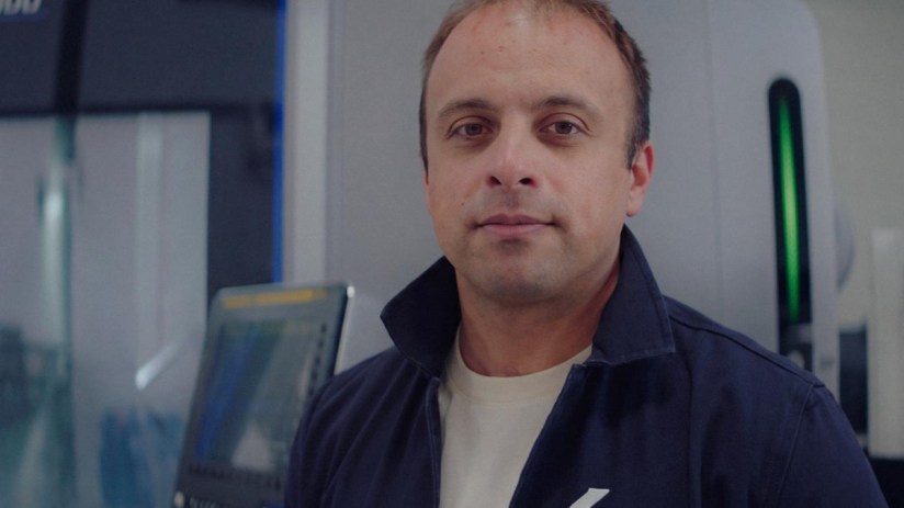 Isembard Alexander Fitzgerald in a navy work jacket, standing in a manufacturing facility