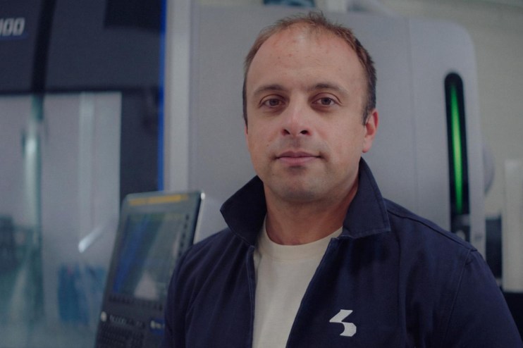Isembard Alexander Fitzgerald in a navy work jacket, standing in a manufacturing facility