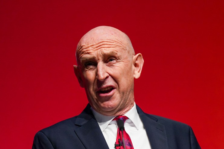 John Healey, the Chancellor, speaking against a red background about AI strategy.