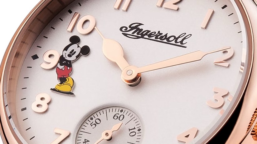 Close-up of a rose gold Ingersoll Mickey Mouse watch face with white dial and small seconds sub-dial.