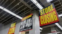 Store Closing signs and a 20% to 40% Off sale sign hanging inside a retail store.
