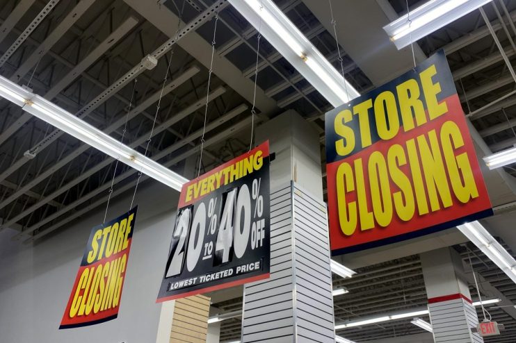 Store Closing signs and a 20% to 40% Off sale sign hanging inside a retail store.