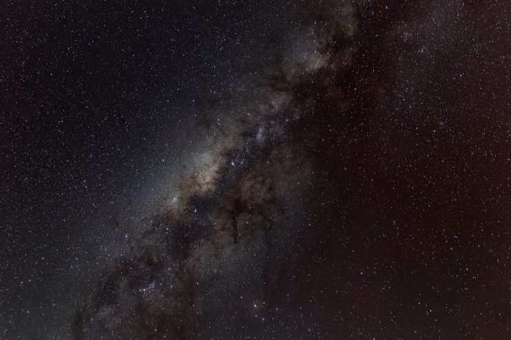 Milky Way galaxy spanning across a dark night sky, filled with countless stars, dust, and nebulae.