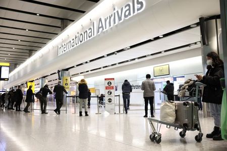 FILE PHOTO: Travellers stand at Terminal 2 of Heathrow Airport, amid the coronavirus disease (COVID-19) outbreak in London