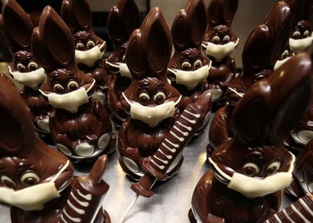 Chocolate bunnies wearing protective masks and holding vaccine syringes